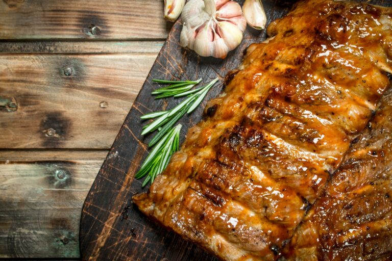 Ribs grill with branches of rosemary and garlic.